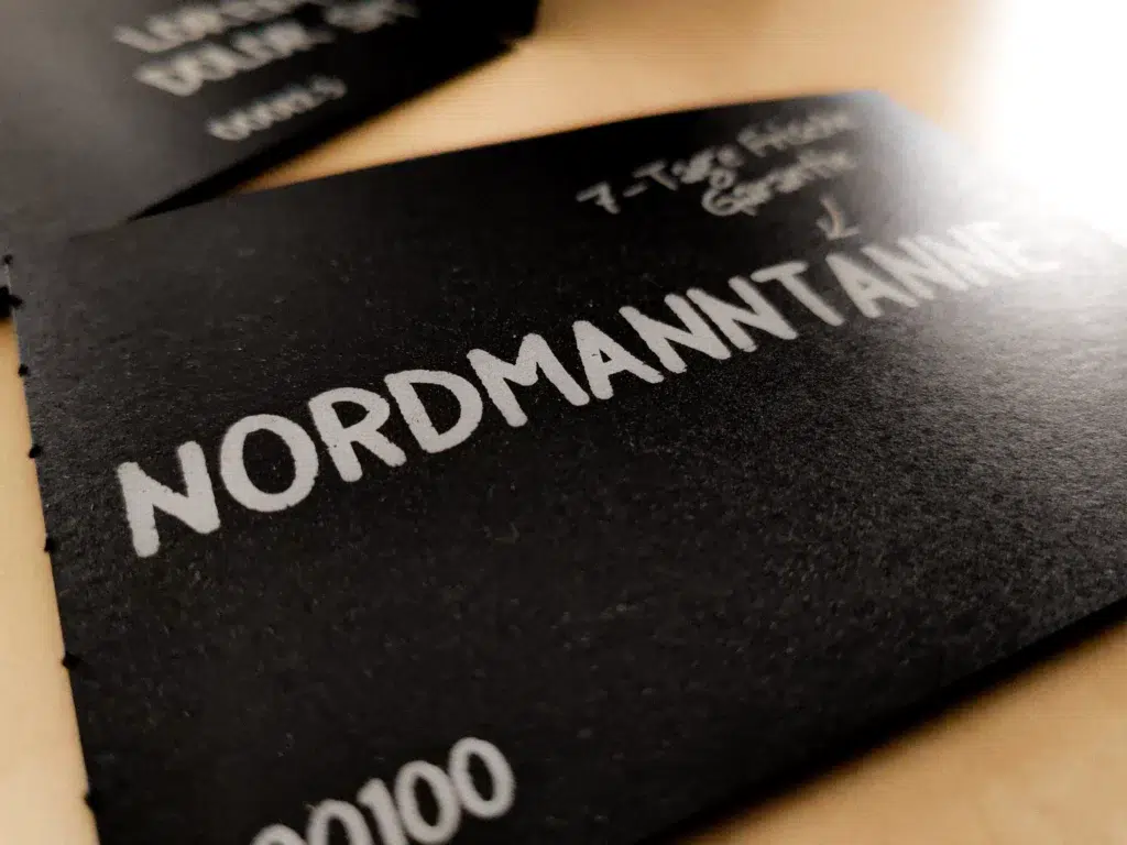 Detailaufnahme der Preisauszeichnungskarten von Blume2000 auf schwarzem Karton und weißer Schrift.